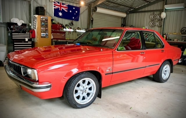Shiny red Holden Torana which is a good example of car paint restoration and protection
